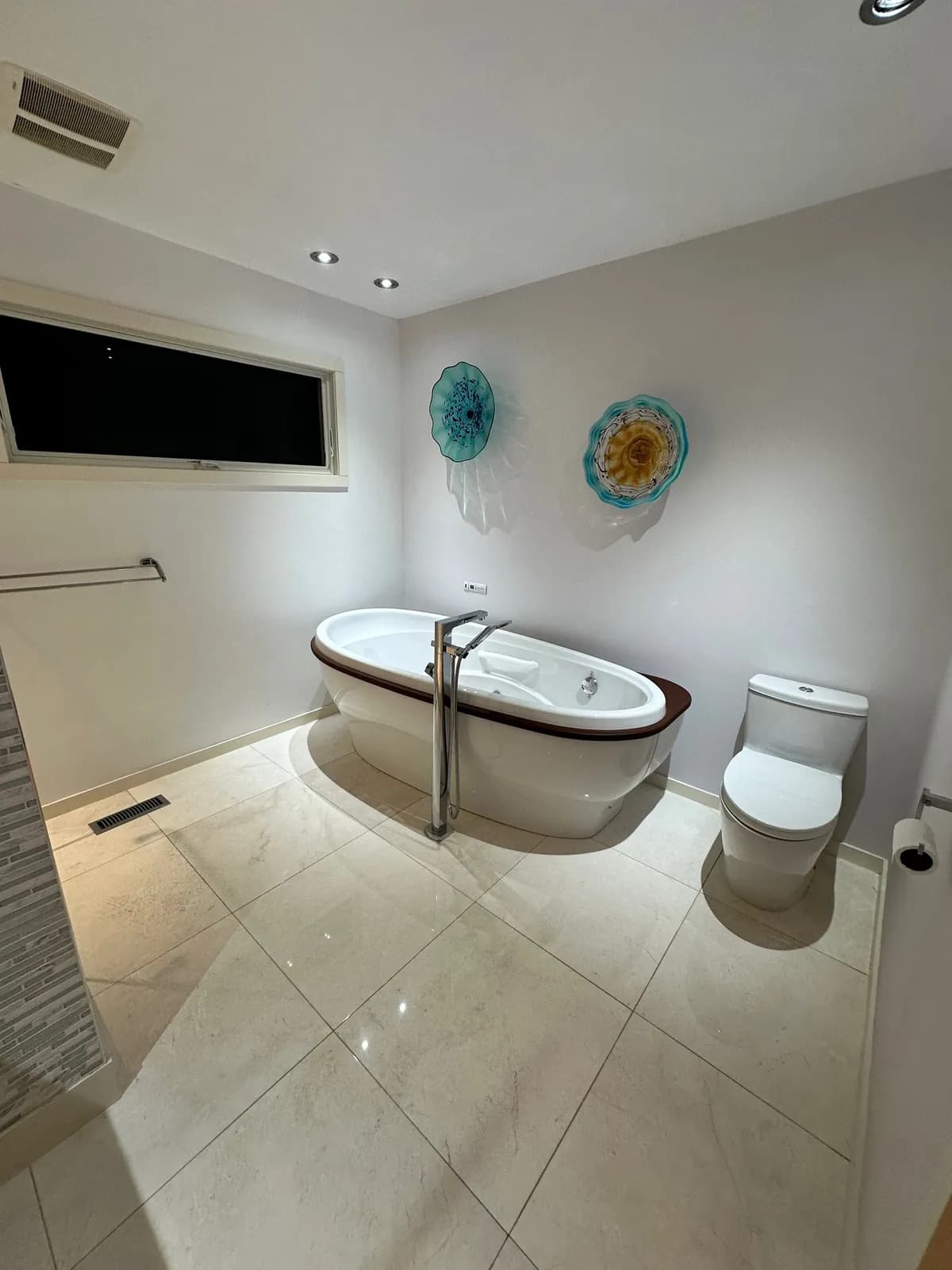 Polished bathroom floor beside a freestanding tub