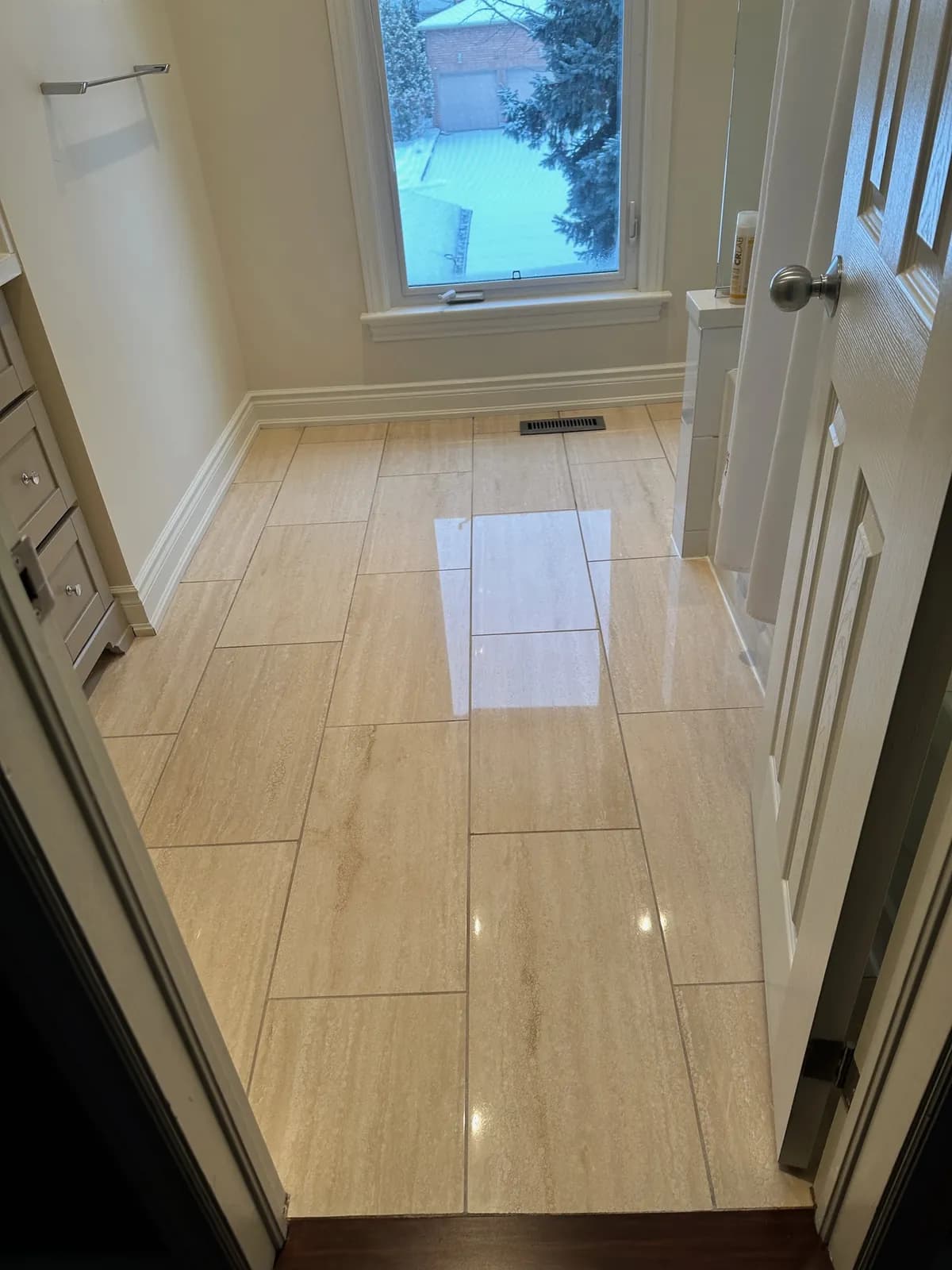 Polished bathroom floor laid in long rectangular tiles