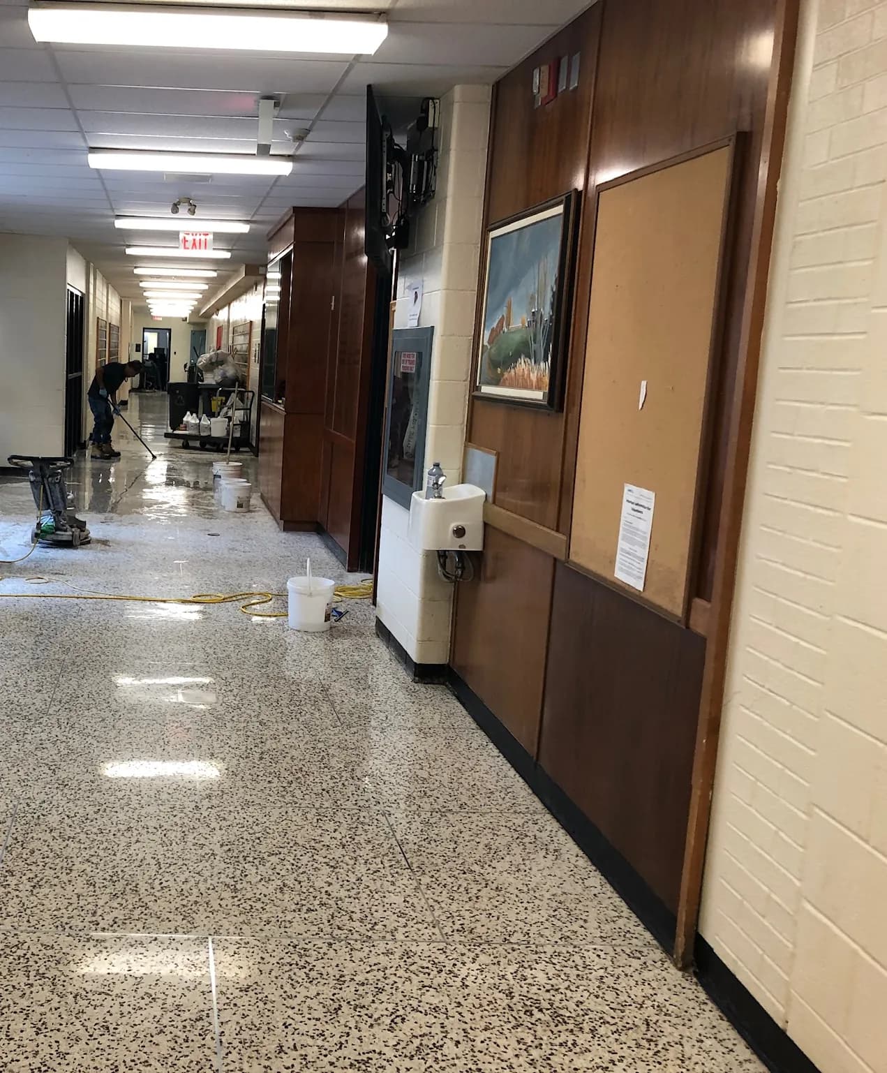Crew polishing a terrazzo corridor in a school
