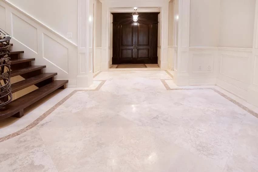 Polished marble entry hall beside a wooden staircase