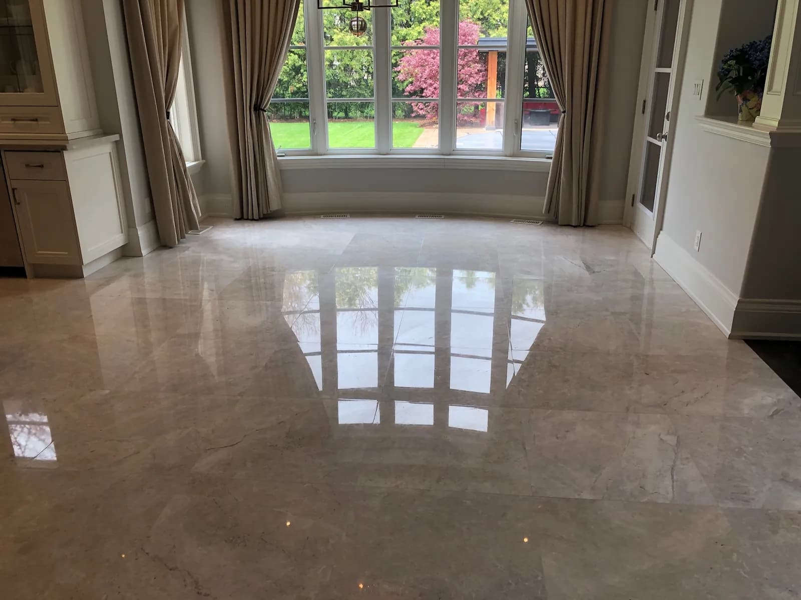 Polished marble floor reflecting a bay window