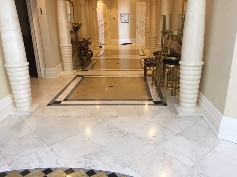 White marble hallway floor with a dark border between columns