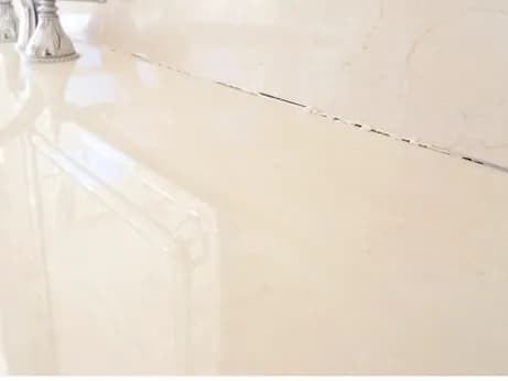 Failed caulking on a marble vanity, before
