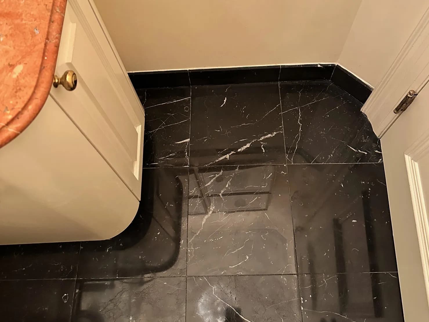 Worn black marble powder room floor, after