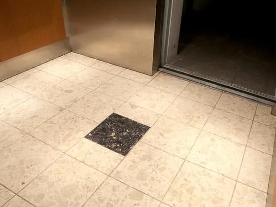 Stained agglomerate marble elevator lobby after restoration