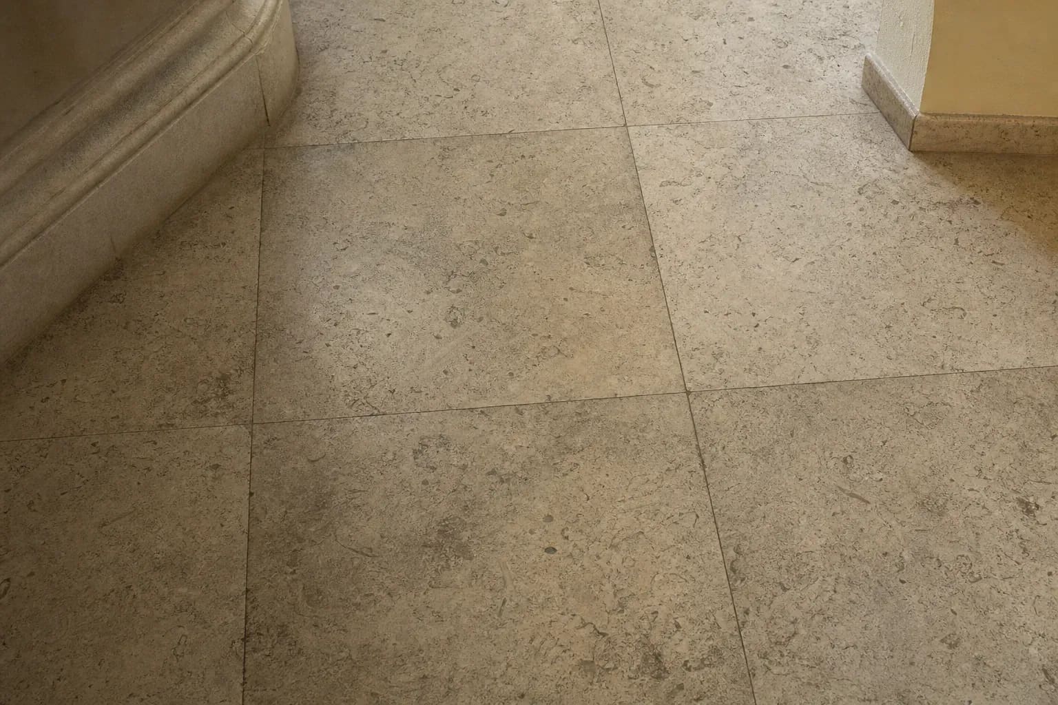 Dull, grimy travertine floor with ground-in dirt and soap film