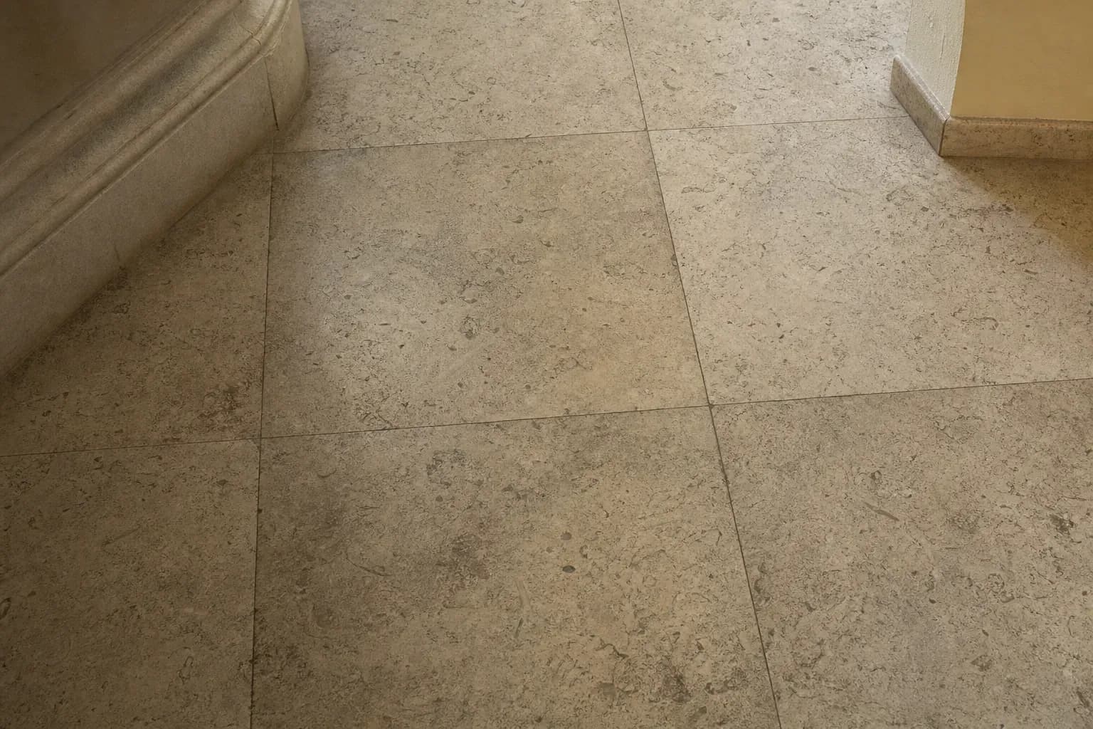 Dull, grimy travertine floor with ground-in dirt and soap film