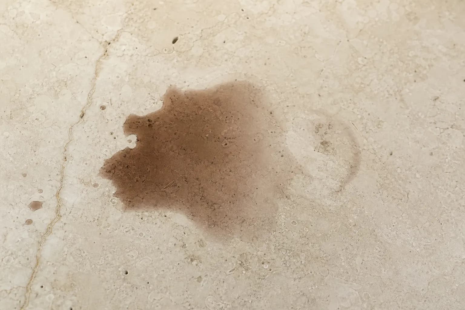 Dark oil and wine stains soaked into a light marble countertop