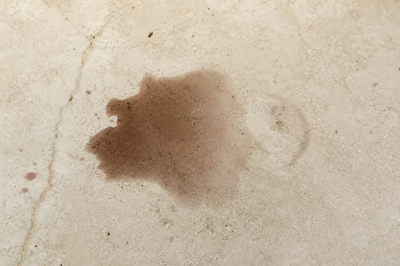 Dark oil and wine stains soaked into a light marble countertop