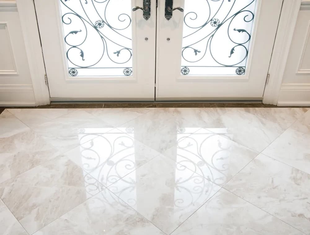 Iron front doors reflected in a marble foyer floor we polished